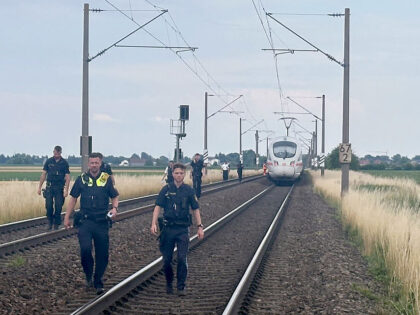03 July 2025, Bavaria, Straßkirchen: Police officers walk through the track bed in front