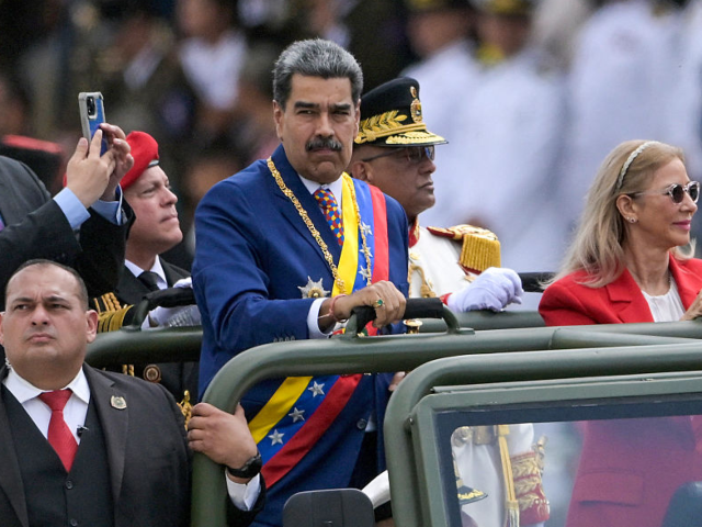 Venezuela's President Nicolas Maduro and First Lady Cilia Flores parade in a military vehi