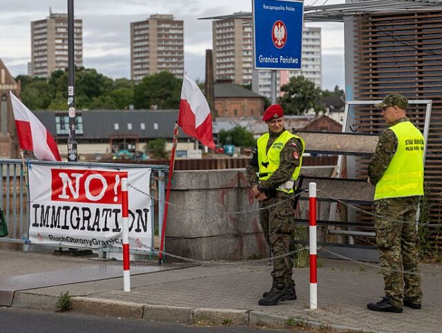 Banners reading "Stop Immigration" and "No! Immigration" are seen as P