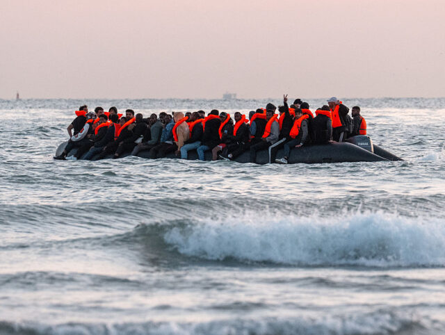 GRAVELINES, FRANCE - JULY 10: A man gestures from a migrant dinghy as it prepares to sail