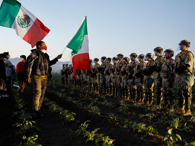 GettyImages-2224606482 CAMARILLO, CALIFORNIA - JULY 10: National Guard members and a federal agent block people p