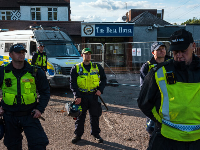 EPPING, ENGLAND - JULY 20: Police officers stand guard at the Bell Hotel as demonstrators