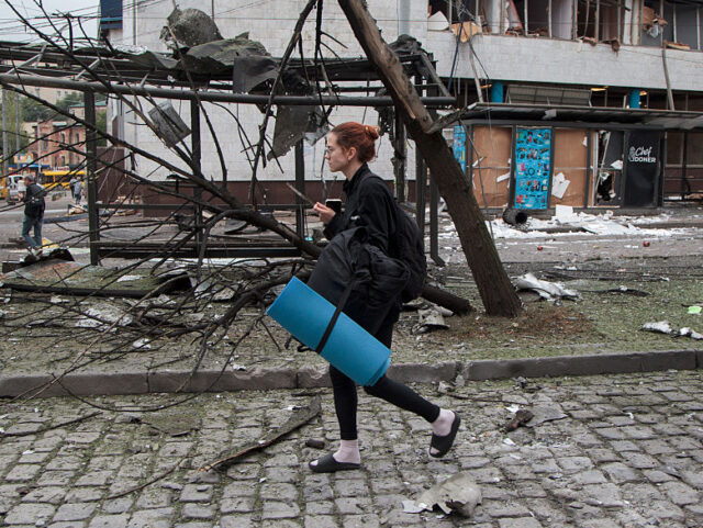 A woman carries a sleeping pad and a backpack after sheltering in the Lukianivska metro st