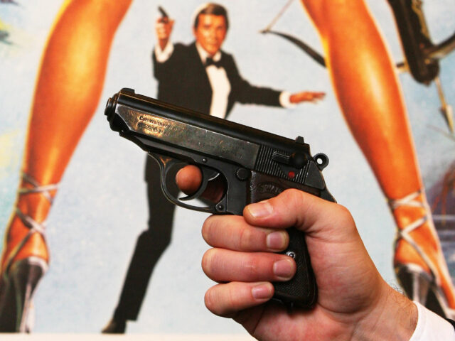 A Walther PPK handgun in front of a poster of the film 'For Your Eyes Only' at Christie's