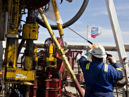 A Nabors Industries Ltd. roughneck uses a power washer to clean the drilling floor of a ri