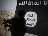 A member of the Iraqi forces walks past a mural bearing the logo of the Islamic State (IS) group in a tunnel that was reportedly used as a training centre by the jihadists, on March 1, 2017, in the village of Albu Sayf, on the southern outskirts of Mosul. Iraqi forces launched a major push on February 19 to recapture the west of Mosul from the Islamic State jihadist group, retaking the airport and then advancing north. (Photo by AHMAD AL-RUBAYE / AFP) (Photo by AHMAD AL-RUBAYE/AFP via Getty Images)