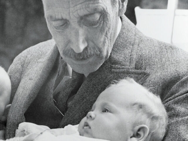 Newborn Princess Margrethe as a baby, is shown in the arms of her grandfather, the late Ki