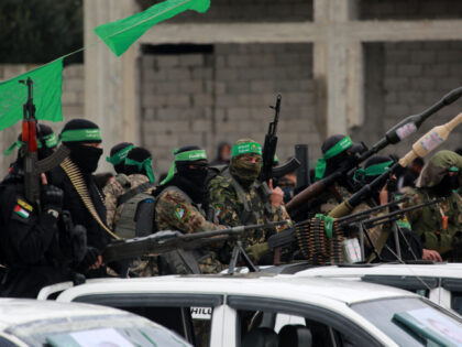 Palestinian Hamas fighters carry their guns in Nuseirat in the central Gaza Strip, as prep