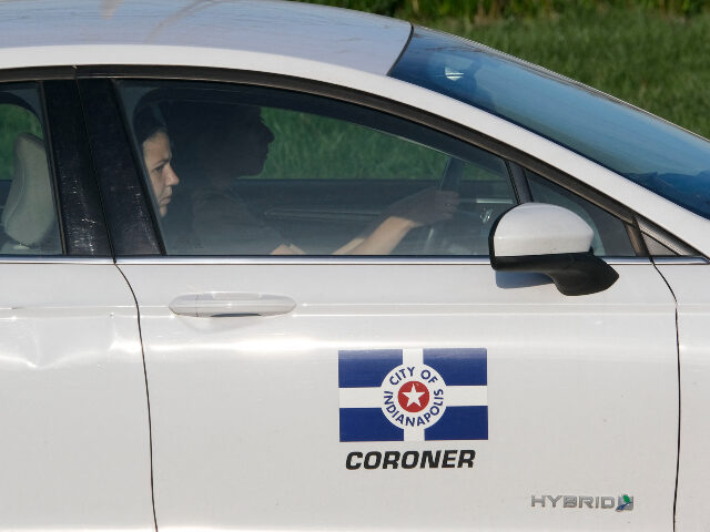 A coroner's vehicle drives to the site of a mass shooting at a FedEx facility in Indi