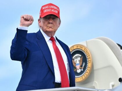 US President Donald Trump pumps his fist as he boards Air Force One at Morristown Municipa