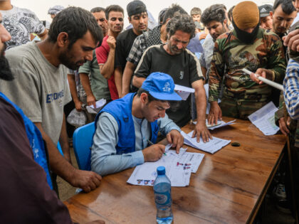 Workers from a local NGO register returnees to receive aid from UNHAS such as blankets and