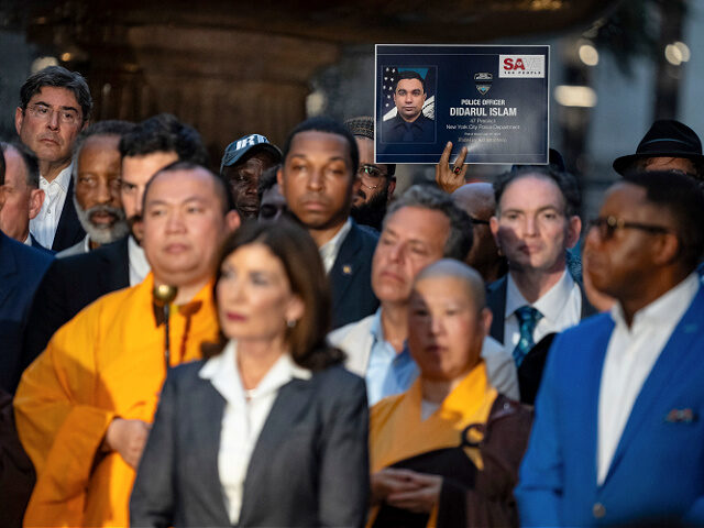 A man holds up a poster in memory of NYPD officer Didarul Islam during a vigil at Bryant P