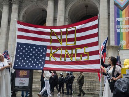 Prior to a huge protest march, two women, wearing long, flowing dresses and sashes, hold a