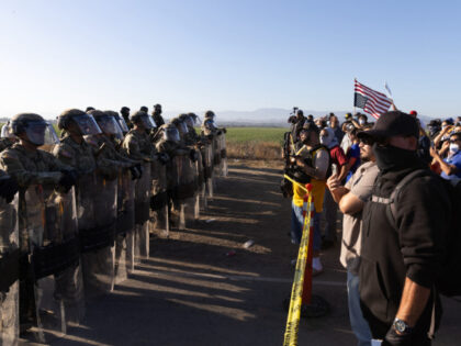California National Guard troops face off with protestors during a Federal Immigration rai