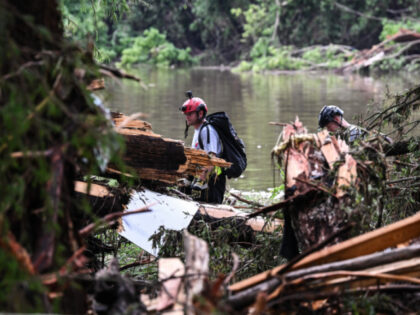 Members of a search and rescue team look for people near Camp Mystic, the site of where at