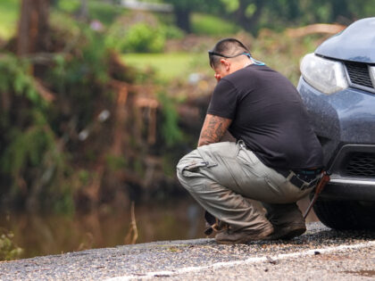 Avi Santos, 23, of San Antonio, Texas, reacts while stopping on the road alongside at Camp