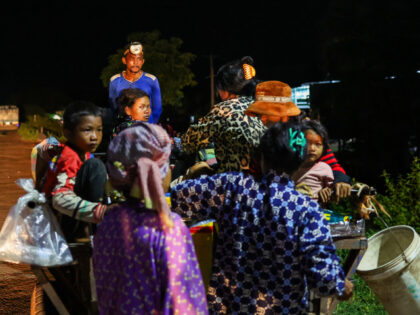 Cambodian children and their family, bringing water and other necessities, flee the confli
