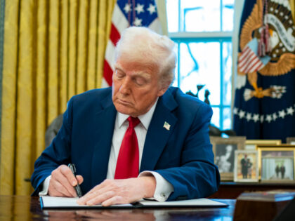 US President Donald Trump signs an executive order in the Oval Office of the White House i