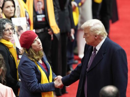 President Donald Trump greets families of hostages held in Gaza at an indoor Presidential