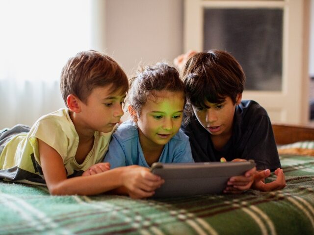 children staring at ipad
