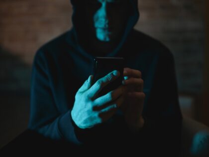 creep looking at his phone in the dark