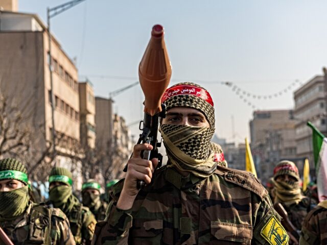 Masked Basiji militant, wearing Hezbollah’s patch, carries a RPG-7 launcher during a par