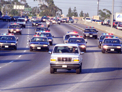 California Highway Patrol chase Al Cowlings, driving, and O.J. Simpson, hiding in rear of