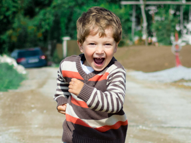 Boy Wearing Red, Brown, and White Stripe Sweater Running