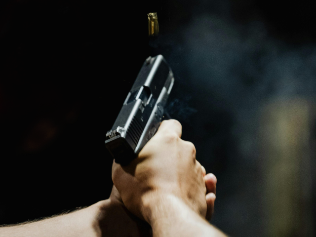Back View of a Person Holding a Gun
