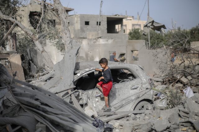 Palestinian children picked through the wreckage around a destroyed home in Deir el-Balah,