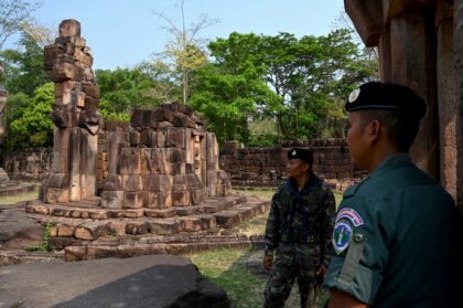 A Cambodian soldier (R) and Thai soldier stand guard at a disputed ancient Khmer temple on