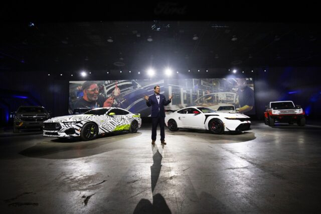 Ford Motor Company President and CEO Jim Farley stands between the Ford Mustang RTR (L) an