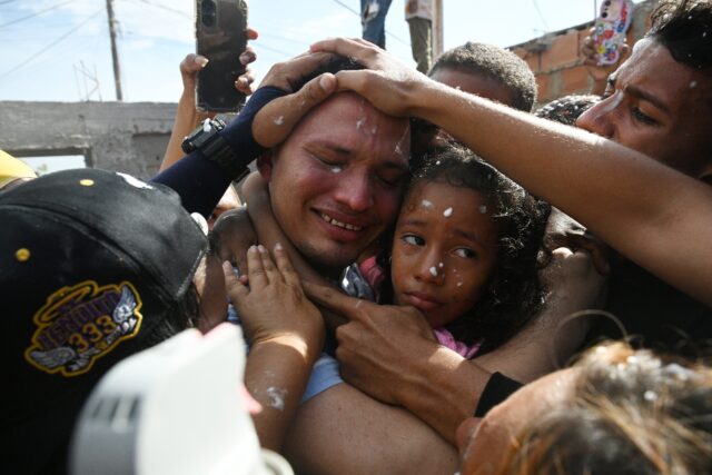 Mervin Yamarte (C), a Venezuelan migrant repatriated from a prison in El Salvador, is welc