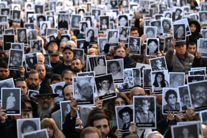 People hold pictures of victims on the 31st anniversary of the AMIA bombing in Buenos Aire