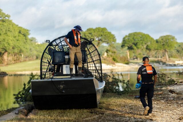 A search and recovery team prepares a fan boat to launch on Guadalupe River in Ingram, Tex