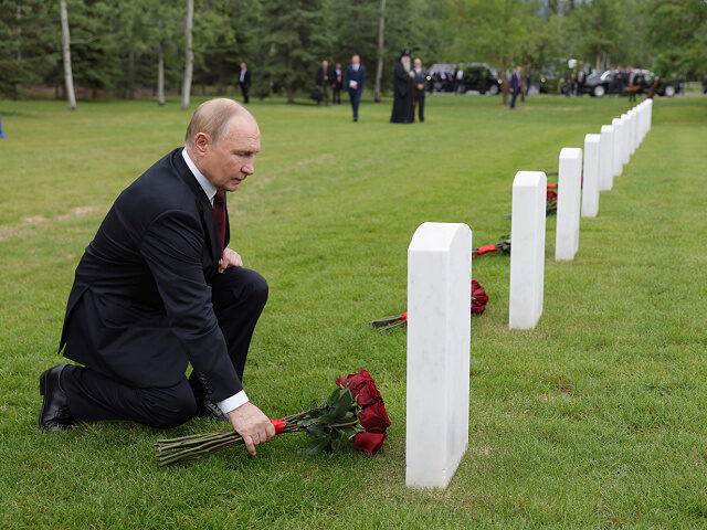 Russia's President Vladimir Putin lays flowers to the graves of Soviet soldiers who died d