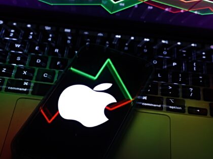 An illustrative stock graph displayed on a laptop screen and Apple logo displayed on a pho