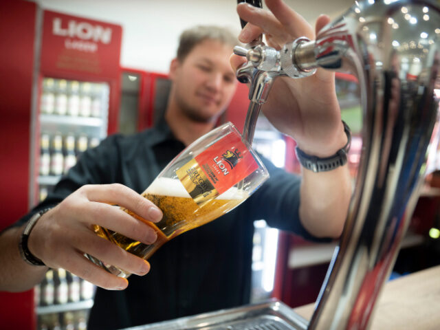 Liam Harrison pours a Lion Lager specially brewed the same recipe of beer that was sold 30