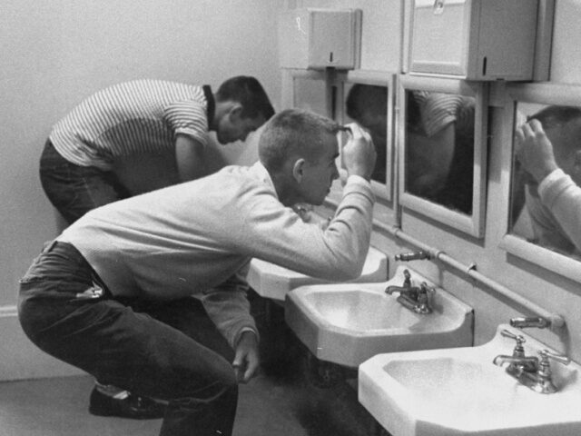 Boys Bathroom High school boys combing their hair in elementary school bathroom. (Photo by Don Cravens/G