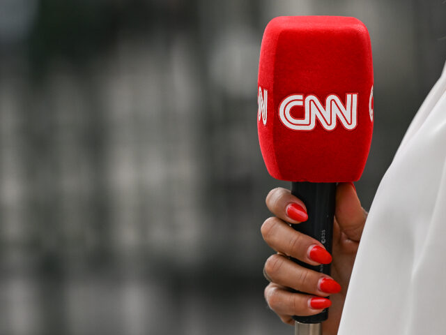 CNN microphone held by a reporter outside the entrance gate to the Palais Bourbon, home to