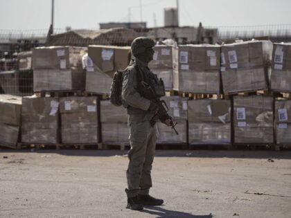 FILE - An Israeli soldier stands beside humanitarian aid packages awaiting pickup on the P