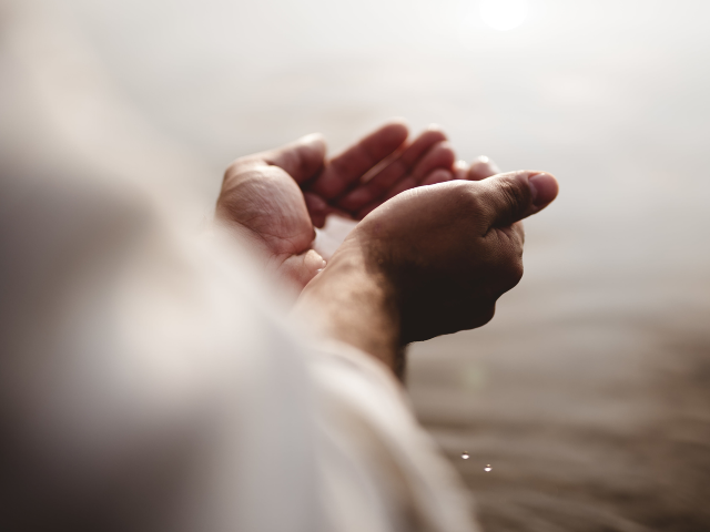 GettyImages-1440283637 A high angle shot of Jesus Christ holding water with his palms