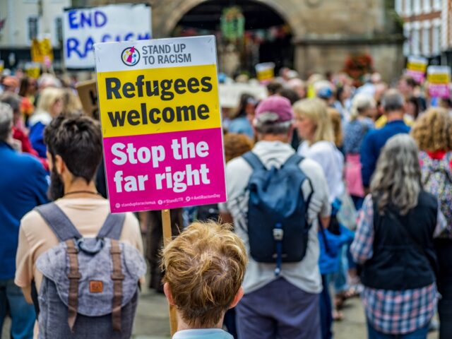 SHREWSBURY, SHROPSHIRE, UNITED KINGDOM - 2024/08/10: A protestor holds a placard saying "R