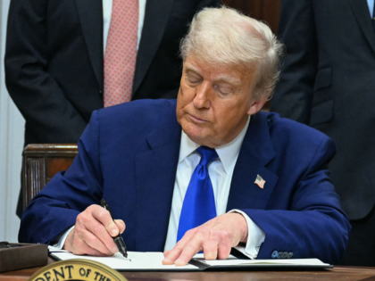 US President Donald Trump signs an executive order on prescription drug prices, in the Roo