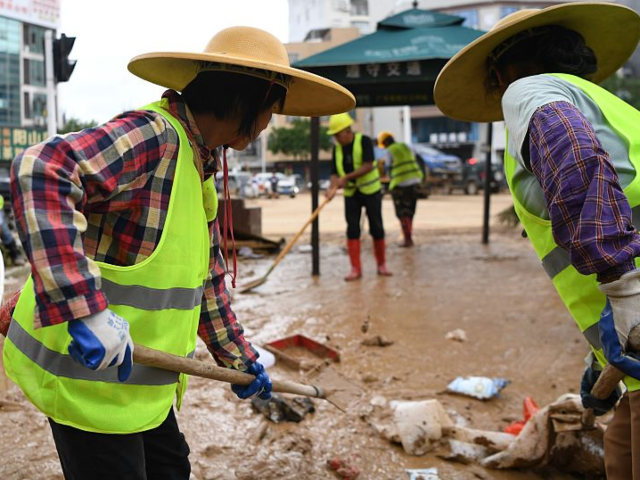 GettyImages-2220499611 Sanitation workers clean up a flood-hit street in Huaiji County, south China's Guangdong P