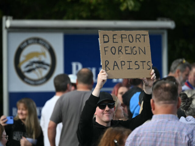 A protester holds up a sign reading 'deport foreign rapists' during a demonstration outsid