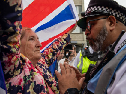 LONDON, ISLINGTON, UNITED KINGDOM - 2025/08/02: A Police liaison officer confronts an anti