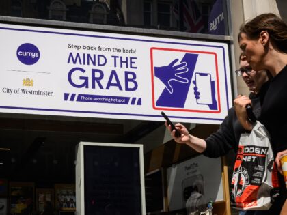 LONDON, ENGLAND - AUGUST 06: Pedestrians walk past newly-installed signage warning people