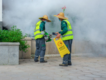 SHENZHEN, CHINA - AUGUST 07: A worker uses a sprayer to eradicate mosquitos at a park in o