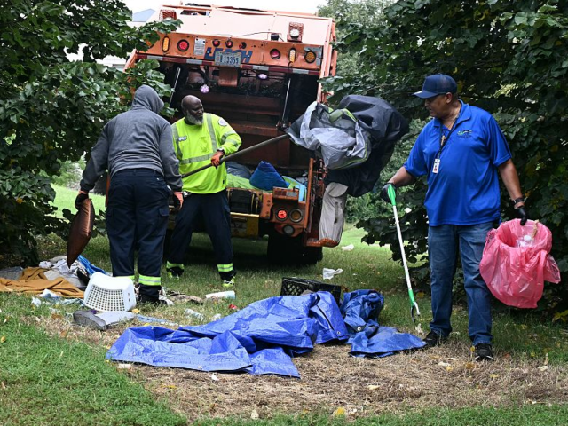 DC city workers dismantle tents and remove personal belongings during a sweep of a homeles